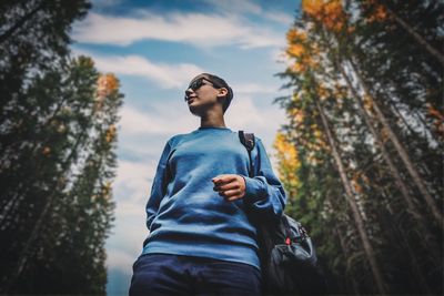 Low angle view of young man looking away in forest