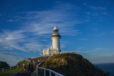 Lighthouse by sea against blue sky