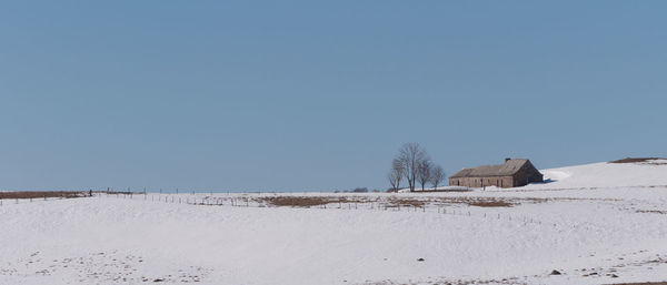 Built structure on land against clear sky during winter