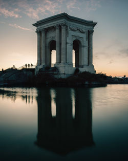 Reflection of building in lake during sunset