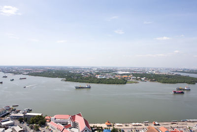 High angle view of cityscape by river against sky