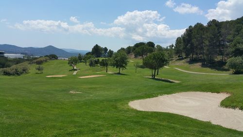 Scenic view of golf course against sky