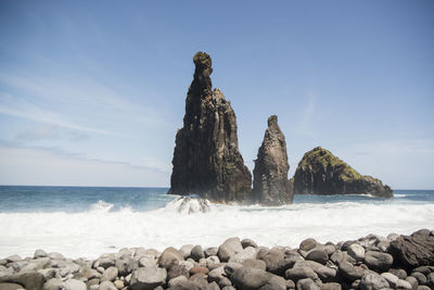 Scenic view of rocks on beach against sky