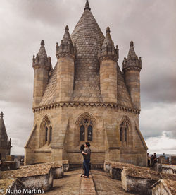 Rear view of woman visiting castle against sky