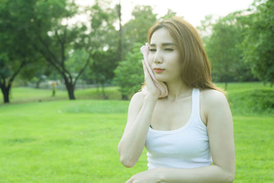 Woman sitting on field at park