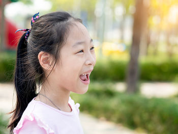 Portrait of a smiling girl looking away outdoors