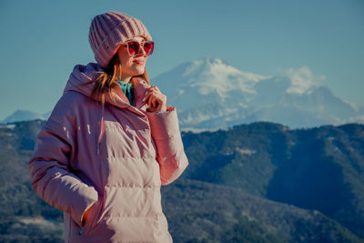 Young woman wearing sunglasses standing on mountain