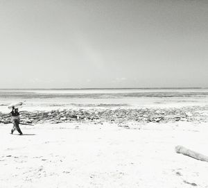 Man standing on beach against clear sky