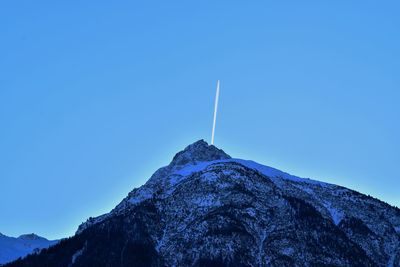 Low angle view of vapor trail against clear blue sky