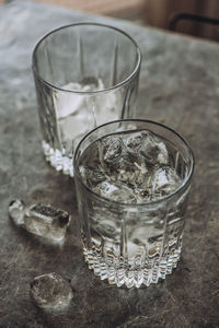 High angle view of drinks with ice cubes on table