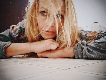 Close-up of thoughtful woman lying on floor