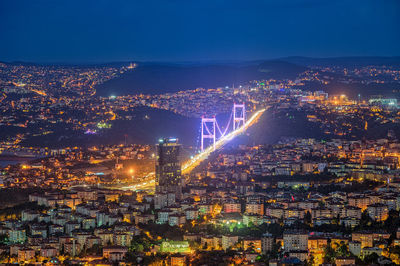 Illuminated fatih sultan mehmet bridge in city at night