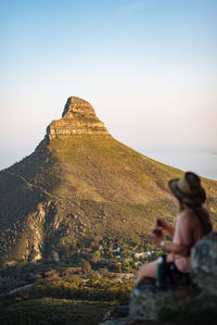 Rear view of man on rock against sky