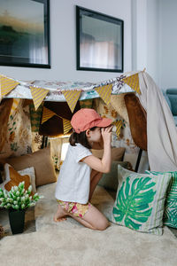 Rear view of girl sitting at home