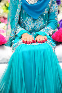 Close-up of woman holding blue umbrella