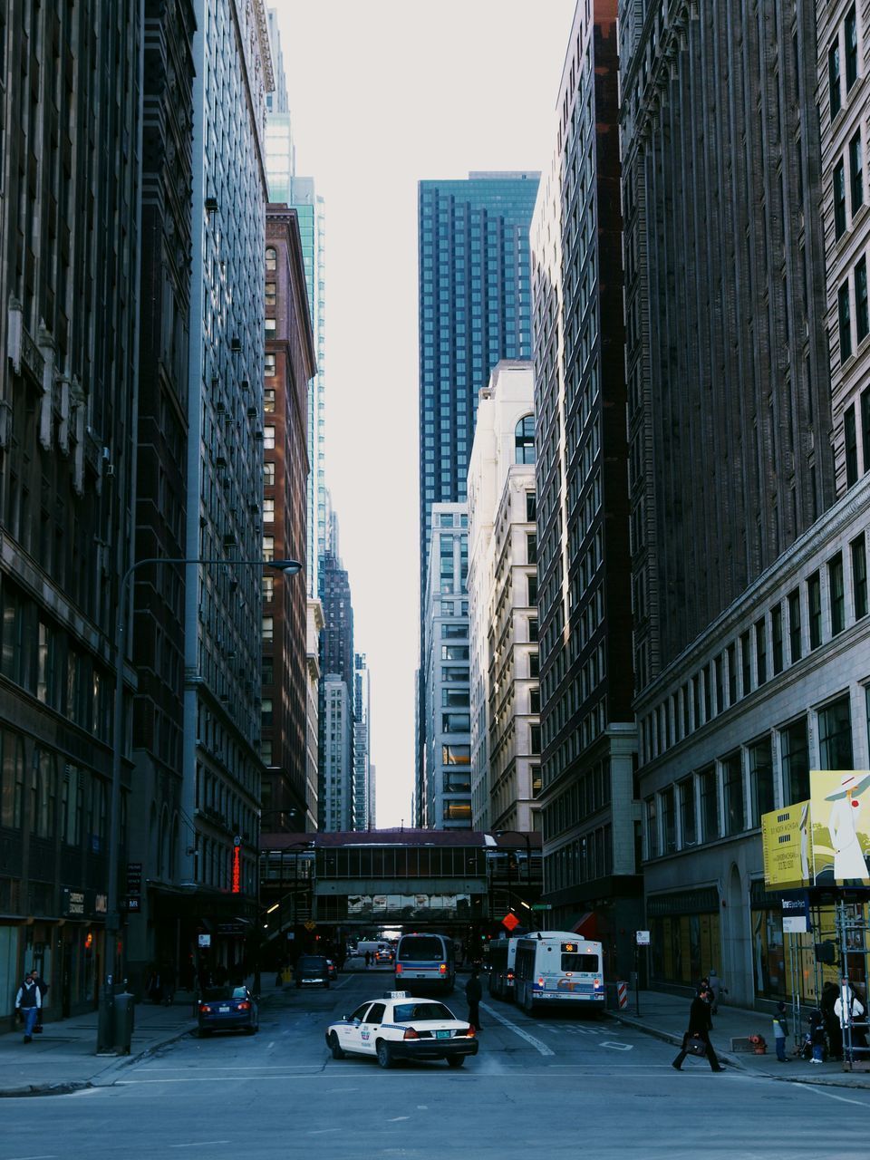 CARS ON CITY STREET AMIDST BUILDINGS IN RESIDENTIAL DISTRICT AGAINST SKY