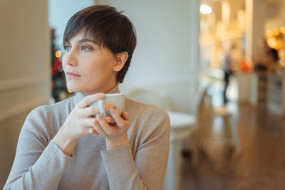 Thoughtful woman sitting in cafe