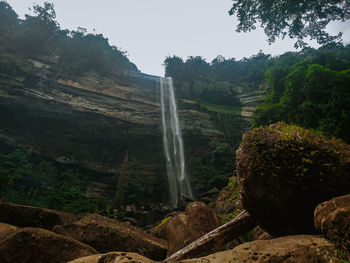 Scenic view of waterfall against sky