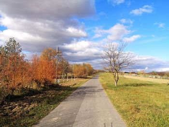Road amidst field against sky