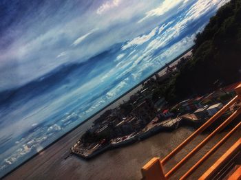 High angle view of sea and cityscape against sky