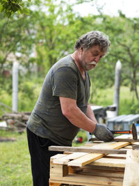 Side view of a man standing on wood