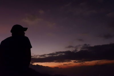 Rear view of silhouette man standing against sky during sunset