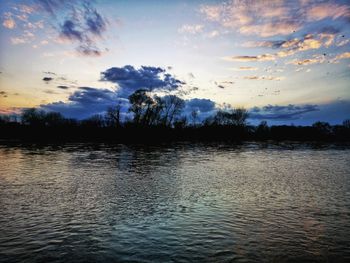 Scenic view of lake against sky at sunset