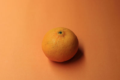 Close-up of apple against orange background