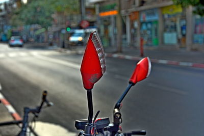 Close-up of red bicycle on road in city
