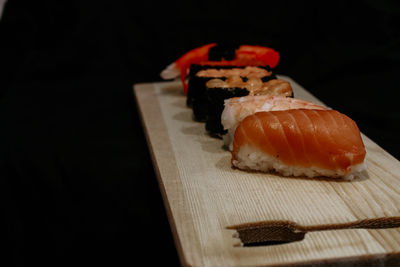 Close-up of sushi served on black background