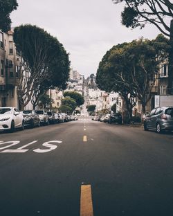 Cars on road in city against sky