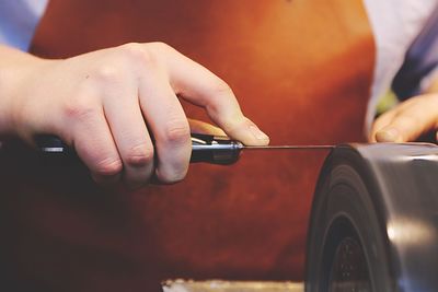 Cropped image of hand sharpening knife