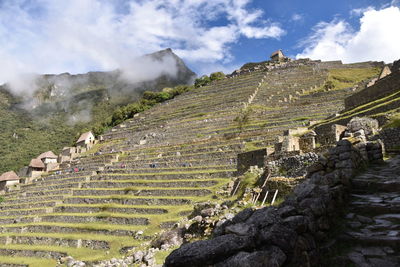 View of ruins of mountain against cloudy sky