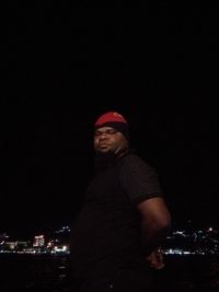 Man standing on illuminated city against sky at night