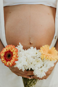 Midsection of woman holding yellow flower