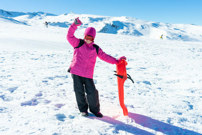 Full length of woman standing on snow covered mountain