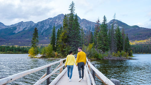 Rear view of man walking on footbridge