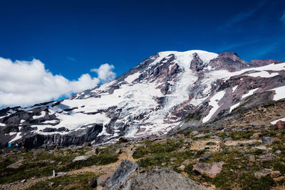 Snowed rocky mountain against blue sky