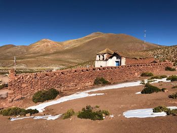 Scenic view of desert against clear blue sky