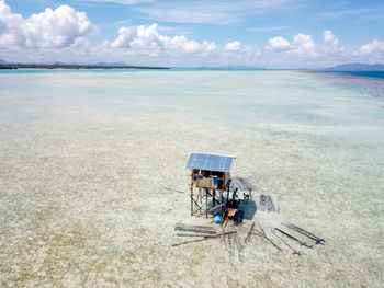 Over water small hut under constructions. blue azure turquoise lagoon with corals in sampoerna.