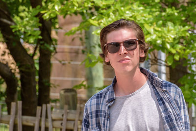 Close-up portrait of confident man wearing sunglasses outdoors