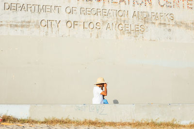 Full length of man with text against wall