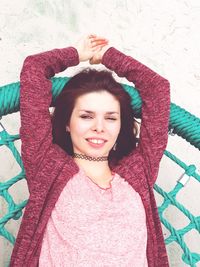 Directly above portrait of woman lying on play equipment at playground