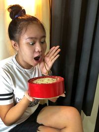 Midsection of girl holding ice cream at home