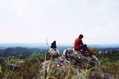 Rear view of woman sitting on landscape