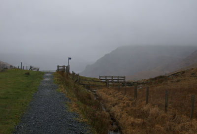 Road leading towards mountains against sky