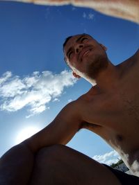 Low angle view of shirtless man against sky