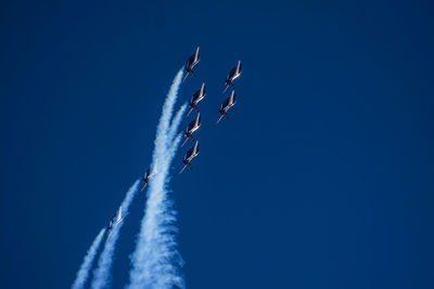 Low angle view of airplane flying against blue sky