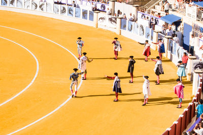 High angle view of athletes standing on sports track during sunny day