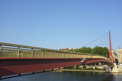 Bridge over river against clear blue sky